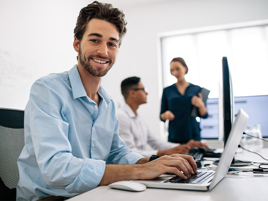 Ein Mann sitzt im Schulungsraum vor seinem Computer und baut mit seiner Umschulung oder Weiterbildung umfassendes Fachwissen auf.